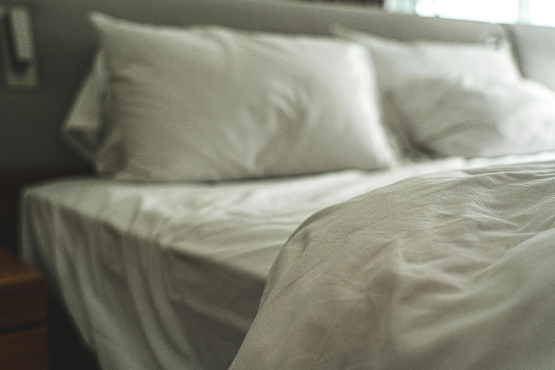 Elegant white bed with satin pillows creating a warm and inviting luxury atmosphere